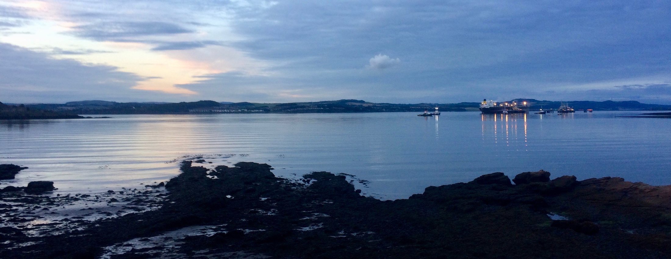 Dusk over the water at Queensferry, Scotland, with ships’ lights in the distance